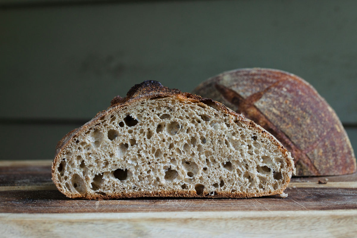 Rustic sourdough boule on a white table